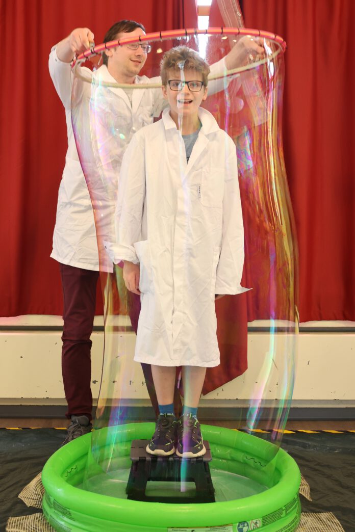 Die StädteRegion Aachen kooperiert bei den MINT-Ferienangeboten mit der RWTH Aachen University und dem Nell-Breuning-Haus. Hier kann zum Beispiel mit Riesenseifenblasen experimentiert werden wie auf dem Foto aus dem Sommerferienprogramm 2024 (damals im Jugendzentrum HOT in Herzogenrath). Foto: Marijke Stasch, StädteRegion Aachen, 2024